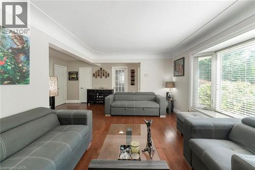 Living area featuring wood-finish flooring, a bay window with blinds, and white crown molding - 1063 Joan Drive, Burlington, ON - Indoor Photo Showing Living Room