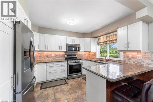 Kitchen featuring white shaker cabinetry, stainless steel appliances, and a tiled backsplash - 1063 Joan Drive, Burlington, ON - Indoor Photo Showing Kitchen With Stainless Steel Kitchen With Upgraded Kitchen