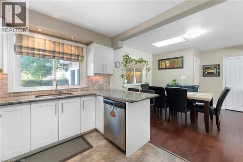 Kitchen with white cabinetry, stainless steel dishwasher, and a stone-finish countertop - 1063 Joan Drive, Burlington, ON - Indoor