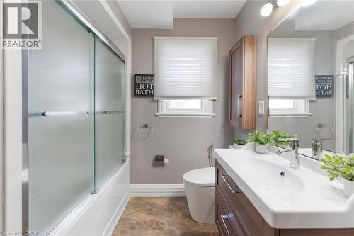 Bathroom featuring a modern vanity with integrated sink, chrome faucet, and wood-finish cabinetry - 1063 Joan Drive, Burlington, ON - Indoor Photo Showing Bathroom