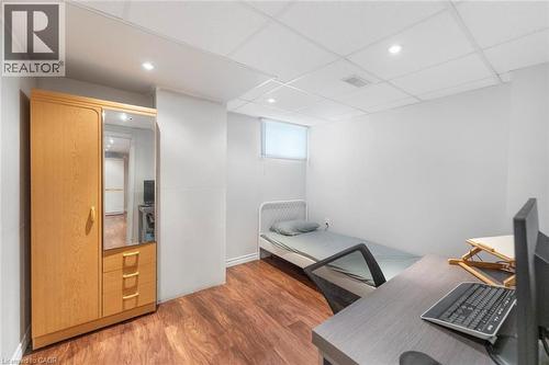 Spacious room featuring wood-finish flooring, white walls, and a drop ceiling with recessed lighting - 1063 Joan Drive, Burlington, ON - Indoor