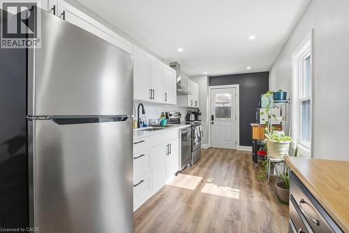 Contemporary kitchen featuring stainless steel appliances, white cabinetry with matte black hardware, wood-finish flooring, and recessed lighting - 773 Lawrence Road, Hamilton, ON - Indoor Photo Showing Kitchen