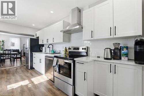 Contemporary kitchen featuring white shaker cabinetry, stainless steel appliances, a subway tile backsplash, and light-tone wood-finish flooring - 773 Lawrence Road, Hamilton, ON - Indoor Photo Showing Kitchen With Upgraded Kitchen