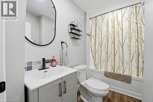 Bathroom featuring a light gray vanity with a white integrated sink, a matte black single-handle faucet, and a black-framed oval mirror - 773 Lawrence Road, Hamilton, ON - Indoor Photo Showing Bathroom