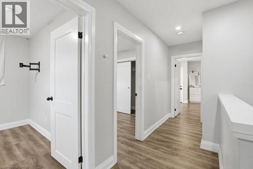 Hallway featuring light gray walls, wood-finish flooring, white trim, recessed lighting, and white interior doors with black hardware - 773 Lawrence Road, Hamilton, ON - Indoor Photo Showing Other Room