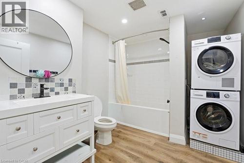 Bathroom featuring a white vanity with integrated sink, black faucet, and a tiled backsplash - 773 Lawrence Road, Hamilton, ON - Indoor Photo Showing Laundry Room