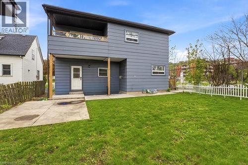 Rear exterior with a second-story balcony, a covered lower patio, and a manicured lawn - 773 Lawrence Road, Hamilton, ON - Outdoor