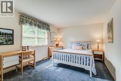 Carpeted room with a large window featuring horizontal blinds - 