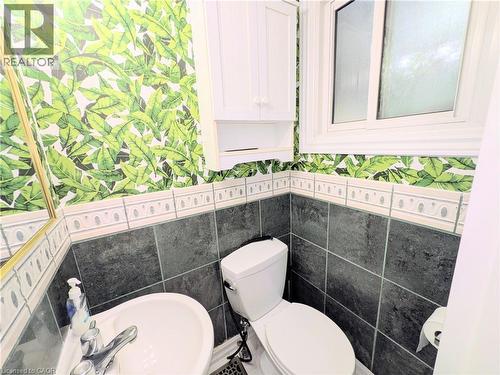 Bathroom featuring a white toilet, pedestal sink, and a white framed window - 22 Riverdale Drive Unit# 1, Hamilton, ON - Indoor Photo Showing Bathroom
