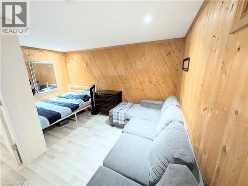 Room featuring wood-paneled walls and light wood-finish flooring - 22 Riverdale Drive Unit# 1, Hamilton, ON - Indoor Photo Showing Bedroom