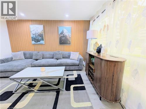 Living area featuring an accent wall with wood paneling, recessed lighting, and a patterned area rug - 22 Riverdale Drive Unit# 1, Hamilton, ON - Indoor Photo Showing Living Room