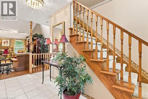 Entryway with tile flooring, a detailed wooden staircase featuring carpeted treads, and an open railing - 39 Everwood Run, Kitchener, ON - Indoor Photo Showing Other Room
