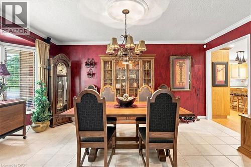 Formal dining area featuring tile flooring, crown molding, a bay window with blinds, and an ornate chandelier with a decorative ceiling medallion - 39 Everwood Run, Kitchener, ON - Indoor Photo Showing Dining Room