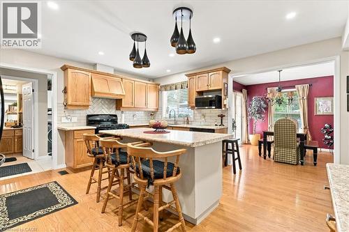 Kitchen featuring wood cabinetry, light-toned countertops, tile backsplash, and recessed lighting - 39 Everwood Run, Kitchener, ON - Indoor