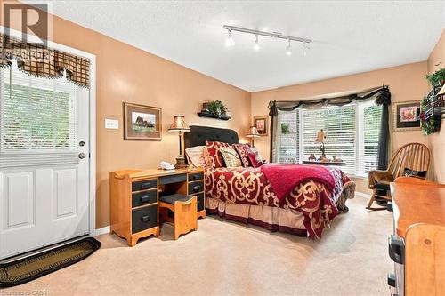 Bay window with horizontal blinds, track lighting, and a paneled exterior door with a window insert - 39 Everwood Run, Kitchener, ON - Indoor Photo Showing Bedroom