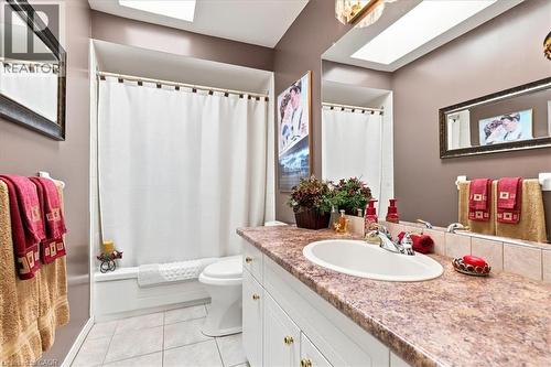 Bathroom featuring a vanity with an integrated sink, a large mirror, and a bathtub with shower - 39 Everwood Run, Kitchener, ON - Indoor Photo Showing Bathroom
