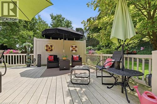 Spacious outdoor deck featuring composite decking, white railing, and a privacy wall with decorative inserts - 39 Everwood Run, Kitchener, ON - Outdoor With Deck Patio Veranda With Exterior