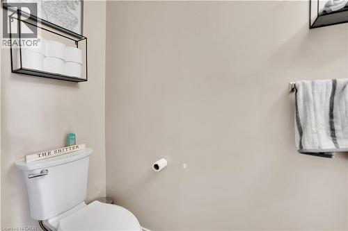 White toilet with polished chrome flush handle, light-toned wall paint, and a wall-mounted towel bar - 60 Featherstone Street, Kitchener, ON - Indoor Photo Showing Bathroom