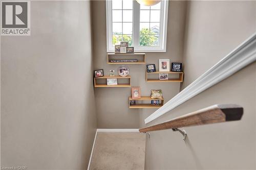 Stairwell featuring a wood handrail, white wall molding, and neutral-toned wall paint - 60 Featherstone Street, Kitchener, ON - Indoor Photo Showing Other Room