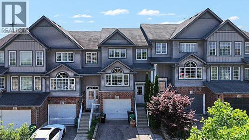 Three-story townhome featuring a mixed-material facade of brick and horizontal siding - 60 Featherstone Street, Kitchener, ON - Outdoor With Facade