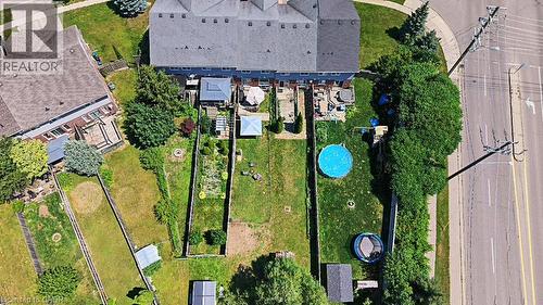 Rear exterior showcasing multiple fenced green spaces with mature landscaping, a deck, and an overhead trellis structure - 60 Featherstone Street, Kitchener, ON -  With View