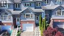 Facade featuring light blue siding with brick accents, white-framed windows, and an arched transom window - 60 Featherstone Street, Kitchener, ON  - Outdoor With Facade 