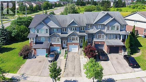 Townhome exterior featuring gray siding, brick accents, white trim, and a dark shingled roof - 60 Featherstone Street, Kitchener, ON - Outdoor With Facade