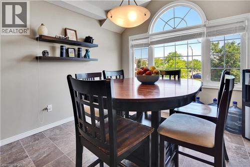 Dining area featuring a large arched transom window, wood-finish flooring, and built-in floating wall shelves - 60 Featherstone Street, Kitchener, ON - Indoor Photo Showing Dining Room