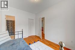 Room with wood-finish flooring, white walls, and a recessed ceiling light - 