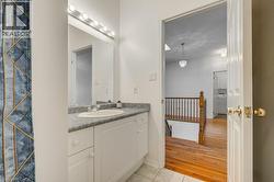 Bathroom vanity featuring a single basin sink, grey countertop, and overhead bar lighting - 