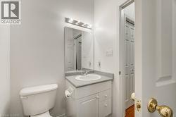 Bathroom vanity featuring a single basin, laminate countertop, and white cabinetry - 