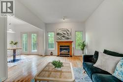 Hardwood flooring throughout, featuring a fireplace with a wood mantel and tile surround - 
