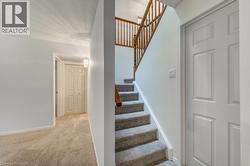 Carpeted staircase featuring wood railings and balusters - 