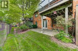 Exterior patio area featuring brick construction and a second-story wooden deck - 