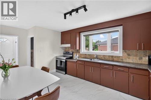 Kitchen featuring dark brown cabinetry, light-toned tiled backsplash, and stainless steel appliances - 236 Hammersmith Court, Burlington, ON - Indoor Photo Showing Kitchen