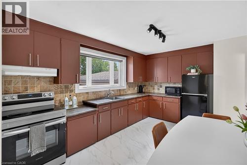 Kitchen with brown cabinetry, marble-look floor tiling, and a tiled backsplash - 236 Hammersmith Court, Burlington, ON - Indoor Photo Showing Kitchen