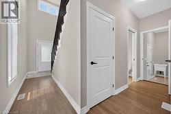 Entryway featuring wood-finish flooring, white baseboards, and neutral wall tones - 
