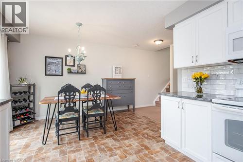 Open-concept living space featuring wood-finish flooring, a contemporary chandelier, and a neutral color palette - 38 David Bergey Drive, Kitchener, ON - Indoor Photo Showing Kitchen