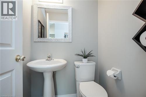 Pedestal sink with chrome faucet, complemented by a decorative mirror and overhead lighting - 38 David Bergey Drive, Kitchener, ON - Indoor Photo Showing Bathroom