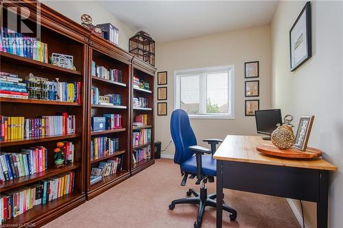 Carpeted room with a double-paned window, featuring built-in wood-finish shelving, and light-toned wall paint - 38 David Bergey Drive, Kitchener, ON - Indoor Photo Showing Office