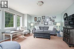 Spacious room featuring multiple windows with grid patterns, light-colored walls, and a ceiling-mounted light fixture - 