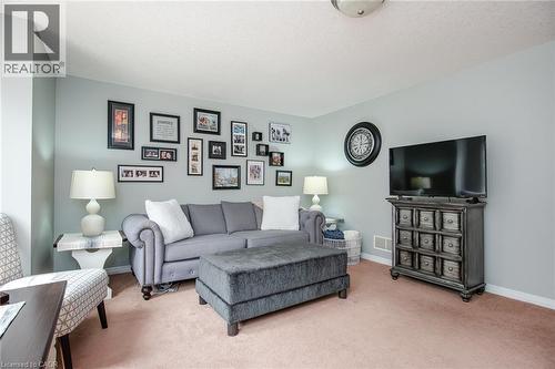 Carpeted living space with light blue-gray walls, a flush-mount ceiling light fixture, and white baseboards - 38 David Bergey Drive, Kitchener, ON - Indoor Photo Showing Living Room