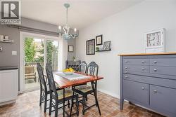 Dining area featuring wood-finish flooring, a sliding glass door providing exterior access, and a light blue chandelier - 