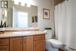 Bathroom featuring a wood-finish vanity with an integrated sink and laminate countertop - 