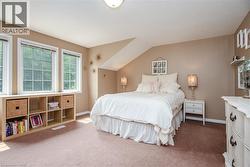 Spacious bedroom featuring multiple windows, a sloped ceiling detail, and built-in cube storage - 