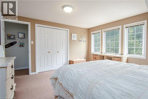 Carpeted room featuring three grid-pattern windows with built-in shelving below - 38 David Bergey Drive, Kitchener, ON - Indoor Photo Showing Bedroom
