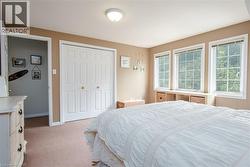 Carpeted room featuring three grid-pattern windows with built-in shelving below - 