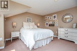 Carpeted room with a vaulted ceiling, neutral wall paint, built-in wall sconce, and ceiling light fixture - 