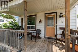 Covered front porch featuring wood-finish decking and railing - 