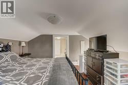 Attic space featuring sloped ceilings, white walls, and a light fixture - 